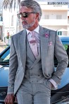 Groom's suit in elegant Prince of Wales gray with a pink stripe.